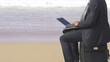 Businessman working on laptop on the beach, super slow motion
