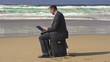 Businessman working on laptop on the beach, super slow motion