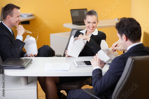 Photo: Business people laughing during lunch break in the office Business people laughing during lunch break in the office