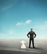 Background with businessman looking forward in desert and arrow