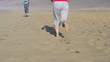 Man and woman jogging on the beach, super slow motion