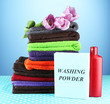 Pile of colorful towels, wash powder and bottle of conditioner