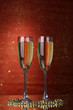 Two glasses of champagne on bright background with lights