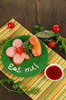 Sausage, greens, tomato on plate on wooden table