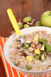 Useful oatmeal in bowl with fruit on wooden table close-up