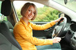 Photo: Portrait of young beautiful woman with key sitting in the car Portrait of young beautiful woman with key sitting in the car