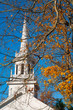 Old-fashioned church spire against a blue autumn sky