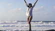 Happy, excited woman standing by the sea, super slow motion