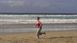 Woman jogging on beautiful beach, super slow motion
