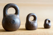 Three small calibration weights on wooden background. Small DOF
