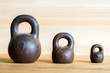 Three small calibration weights on wooden background