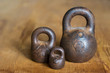 Three small calibration weights on wooden background