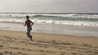 Woman jogging on beautiful beach, super slow motion