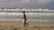 Young woman jogging on beautiful beach in the morning