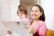Photo: Mature woman and girl reads newspaper Mature woman and girl reads newspaper