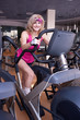 Foto: Beautiful blonde womanr doing exercise on bike in gym Beautiful blonde womanr doing exercise on bike in gym