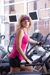 Foto: Beautiful blonde woman doing exercise on bike in gym Beautiful blonde woman doing exercise on bike in gym