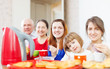 family drinks tea and eats cakes
