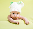 baby girl is lying on green bed