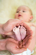 Photo: father hands holding small baby's feet father hands holding small baby's feet