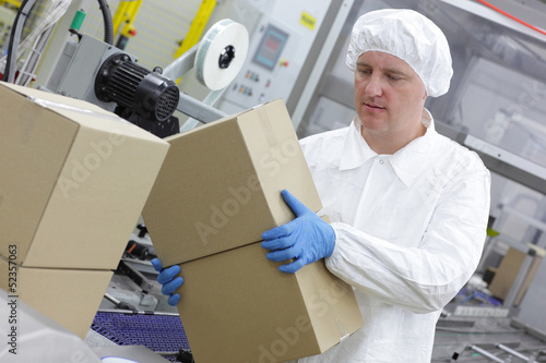 Photo: manual worker at production line dealing with boxes manual worker at production line dealing with boxes