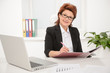 Adult businesswoman working on documents in office