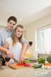 Couple chopping peppers and drinking wine