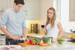 Man cooking with woman drinking red wine