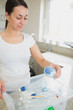 Woman putting bottles into recycling bin