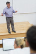 Explaining teacher standing in a lecture hall