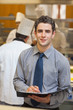 Smiling waiter writing in folder