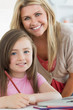 Laughing mother and daughter drawing