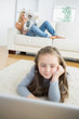 Photo: Girl working with laptop with her mother reading the newspaper Girl working with laptop with her mother reading the newspaper