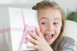 Photo: Surprised girl shaking a present Surprised girl shaking a present