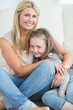 Mother and daughter hugging in living room