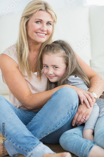 Photo: Mother and daughter hugging in living room Mother and daughter hugging in living room
