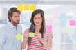 Colleagues pasting sticky note