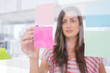 Young woman pointing sticky note with her pen