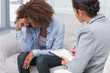 Photo: Woman sitting on therapists couch looking down Woman sitting on therapists couch looking down