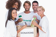 Foto: Happy volunteers putting food in donation box Happy volunteers putting food in donation box