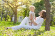 beautiful young mother and osn  relaxing sitting grass backgroun