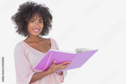 Photo: Beautiful woman holding photo album and smiling at camera Beautiful woman holding photo album and smiling at camera