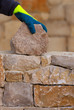 Photo: Mason hands working on masonry stone wall Mason hands working on masonry stone wall