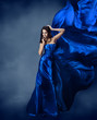 Foto: Woman in blue dress with flying silk fabric Woman in blue dress with flying silk fabric