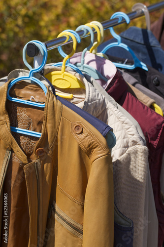 Photo: clothes and leather jacket displayed at garage sale clothes and leather jacket displayed at garage sale
