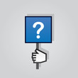Hand holding sign with question mark