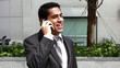 Handsome hispanic businessman talking at phone
