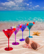colorful cocktail in a row with cherry on tropical sand beach