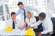 Four architects working on blueprints