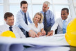 Business people laughing and working on construction plan